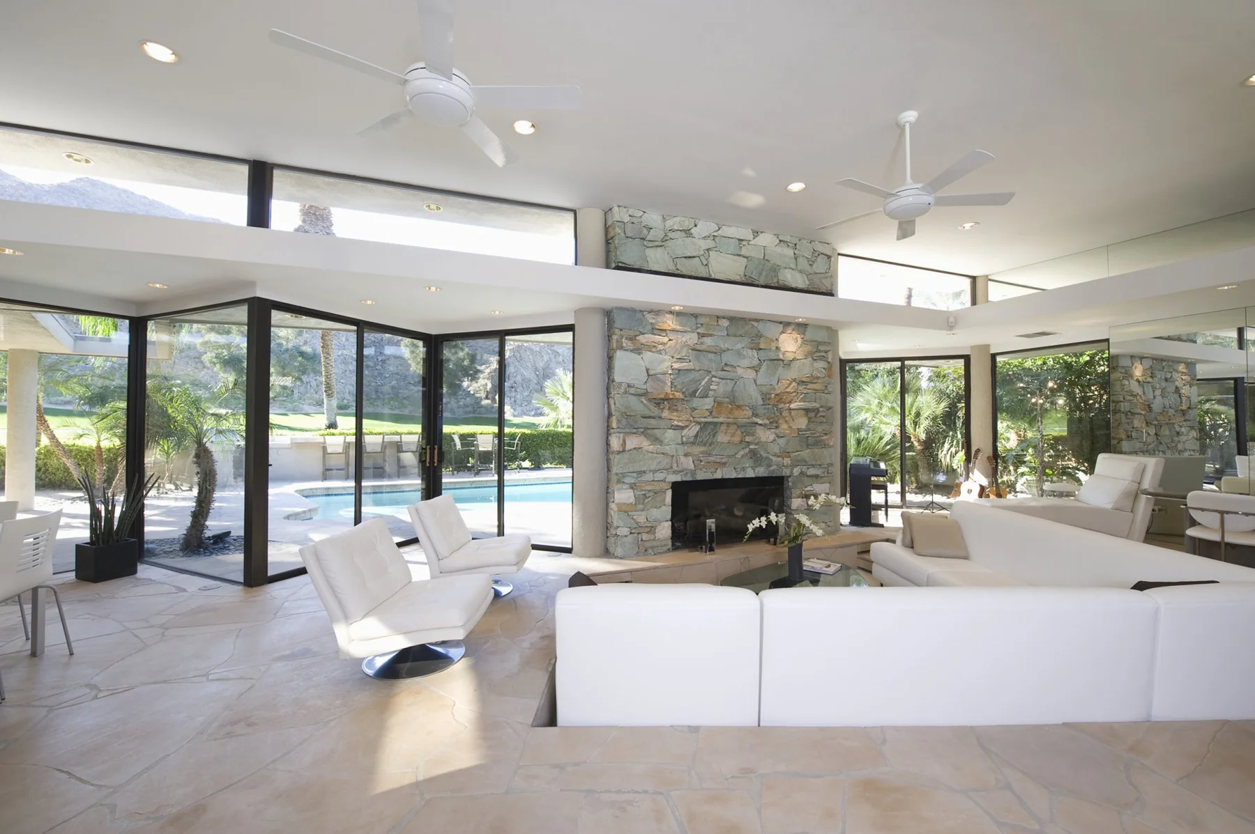Bright living room with large windows overlooking a pool